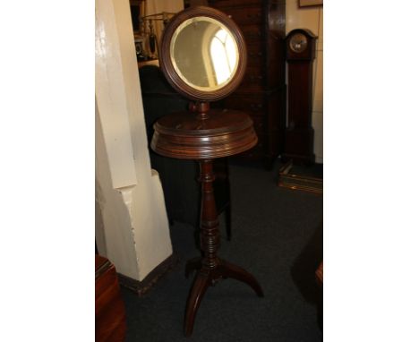 A Victorian mahogany shaving stand with circular adjustable mirror above circular 'box' with two hinged flaps, on turned balu