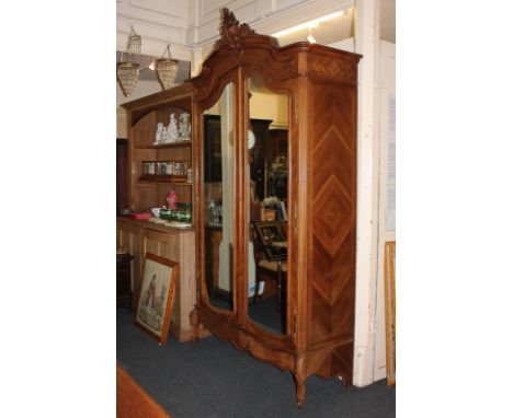 A 19th century French style armoire in oak veneer, with scroll surmount above two mirrored doors enclosing rail, shelf and dr