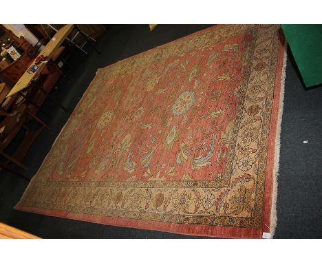 A hand woven Zeigler (Ziegler) wool carpet of floral design on soft red ground and multi-line border 245cm by 296cm (TG)