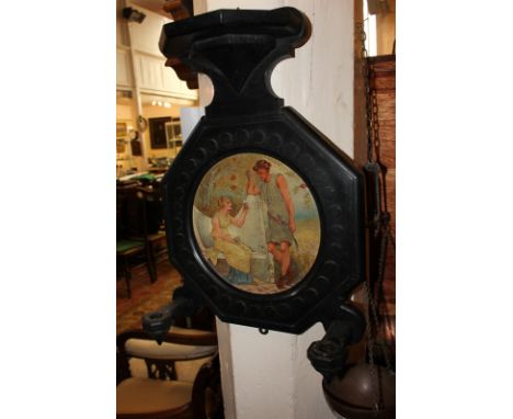 An ebonised wall mount with shelf surmount and two candle holders, circular picture plaque of two painted classical figures, 