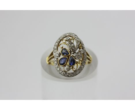 A sapphire and diamond ring, millegrain set with pear shaped sapphires and graduated small diamonds