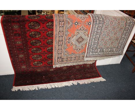 A Bokhara carpet, red ground with repeat elephant foot motif, 198cm by 140cm, together with two Turkish wool runners, terraco