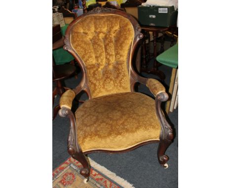 A Victorian mahogany button back armchair, scroll carved frame and open arms, on cabriole front legs and castors