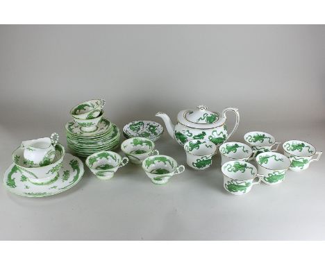 A Wedgwood green Chinese tigers part tea service to include a teapot, five cups, and a Coalport part tea service of five cups