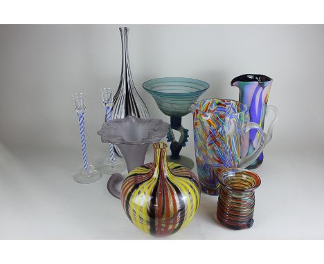 A collection of coloured glass vases and jugs, including a Mdina ribbed orange and green glass vase, vintage striped glass va