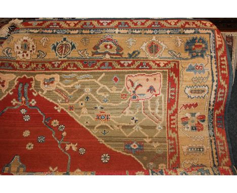 A Kadjar design woven wool carpet, highly decorated with flora and fauna, central stylized blue and cream floral motif on red