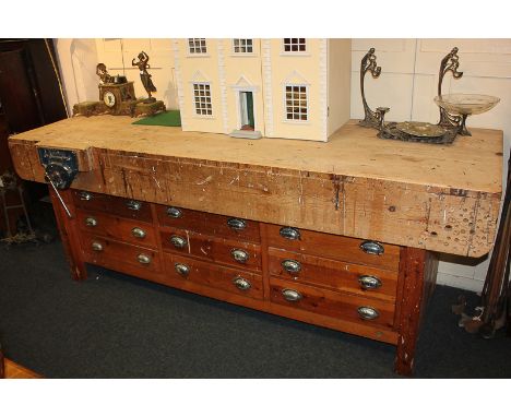 A large wooden carpenter's bench with vice and pencil sharpener, above nine drawers, on block supports, 233.5cm
