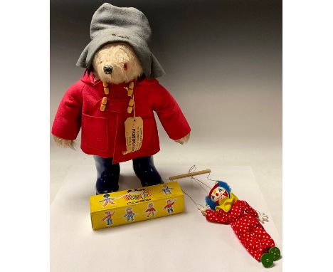 A Gabrielle Designs Paddington Bear, grey felt hat, red felt duffel coat, navy blue Wellington Boots, original paper label, 5