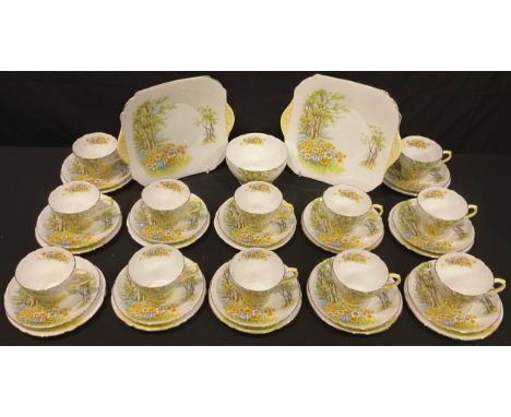 A Shelley Daffodil Time tea set, comprising twelve teacups and saucers, sugar bowl, pair of bread and butter plates, pattern 