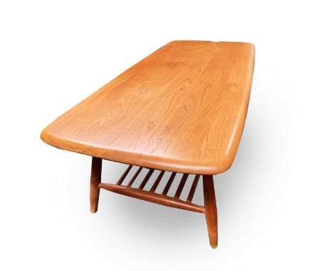 An Ercol light elm coffee table, raised on turned beech legs with a spindle undertier, height 38cm, width 104cm, depth 47cm.C