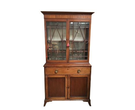 A mahogany two part cabinet, 19th century, the upper part with two glazed doors, the lower with a long drawer above two doors