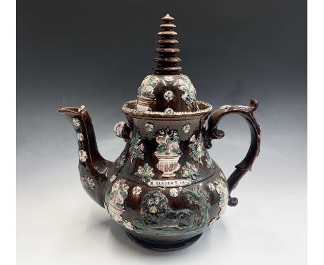 A Measham treacle glazed barge ware teapot, dated 1876, of large proportions, the domed cover with 'Stupa' style finial, appl