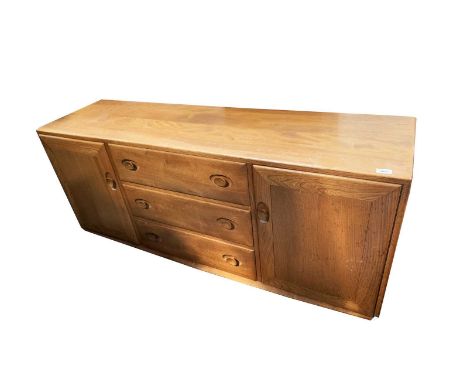 An Ercol light elm sideboard, probably 1970s, fitted three central drawers, flanked by two cupboards, height 69cm, width 156c
