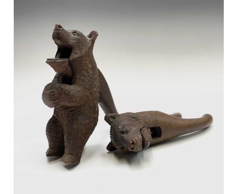 A Black Forest carved bear head nutcracker, circa 1920, with inset glass eyes, height 20cm, together with a similar full leng