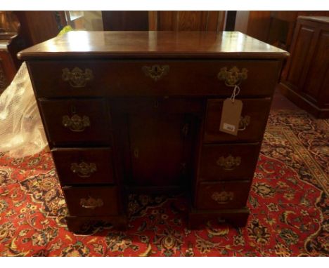 A Georgian mahogany kneehole desk, with eight drawers, one cupboard door, raised on bracket feet, H.76 W.80 D.49cm 