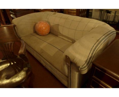 A 20th century chesterfield sofa, with canvas upholstery, raised on bun feet and castors 