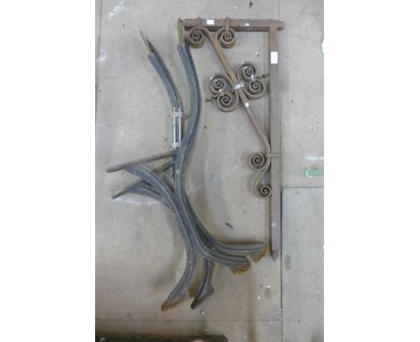 A Victorian wrought iron wall bracket and a pair of cast iron bench ends