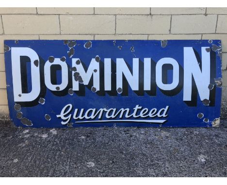 A Dominion Guaranteed rectangular enamel sign by Franco, 72 x 30". 