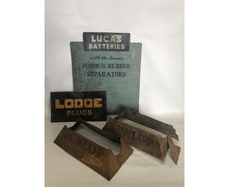 A small Lodge Plugs rectangular tin sign, two Dunlop Tyre racks and a Lucas Batteries hardboard sign. 