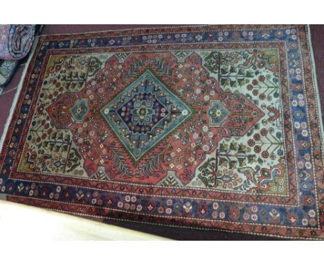 A fine North West Persian Nahawand rug, central diamond medallion with repeating petal motifs on a terracotta field guarded b