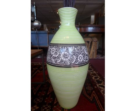 A contemporary ceramic baluster vase, with central floral decorated band on green and white striped body, having faux flowers