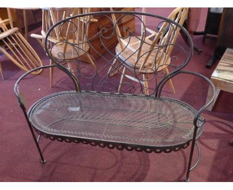 A wrought iron two seater garden bench 