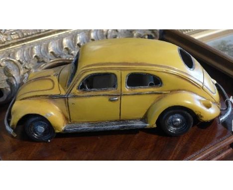 A yellow metal model of a Volkswagen Beetle, 33cm long 