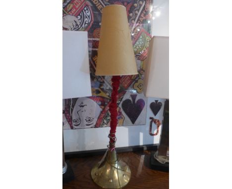 A table lamp with brass base and red velvet stem 