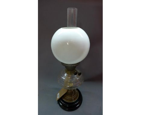A Victorian brass and glass oil lamp on stepped ebonised base, (small crack to reservoir) H.57cm 