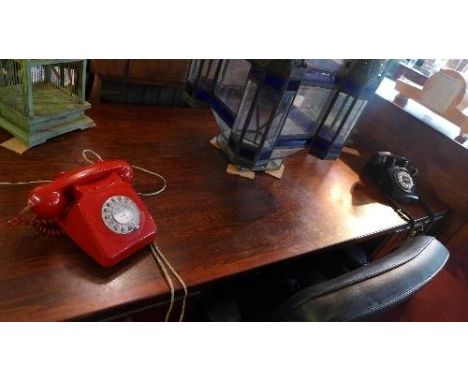 A vintage red telephone and a black reproduction version 