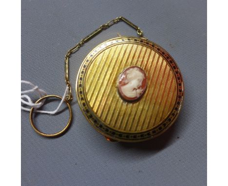 A gilt metal compact with engine turned design top with cameo depicting a lady to centre within floral border 