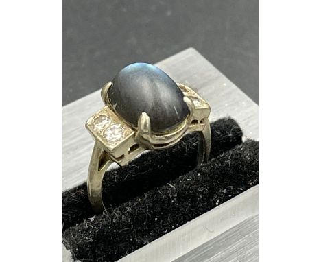 A vintage ring with two diamond shoulders and central blue stone on platinum band. Size G