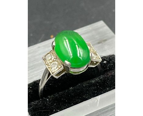 A jade ring with two stone diamond shoulders on a platinum setting Size L