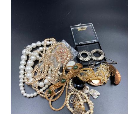 A small volume of costume jewellery to include brooches, pearl necklaces etc.