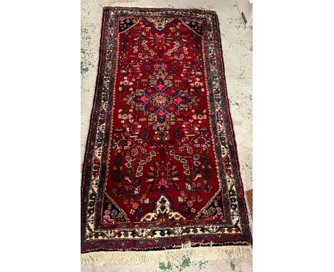 A hand knotted Iranian carpet/rug (220cm x 104cm)