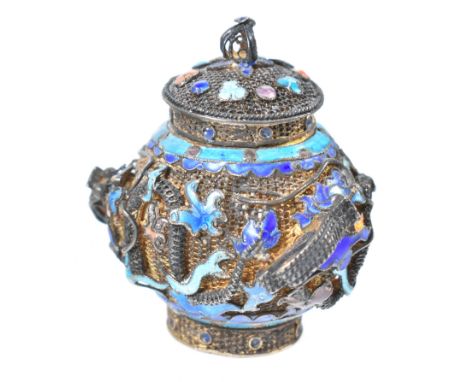 An early 20th century Chinese export white metal and gilt and enamel pot. The silver pot overlaid with silver filigree work a