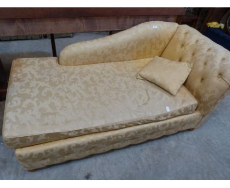 A chaise-longue sofa bed upholstered in gold brocade