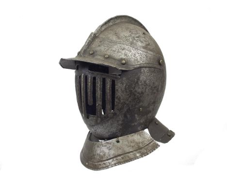 An early 17th Century North European Cuirassier's close helmet, the two-piece skull with turned low comb, the shallow peak wi