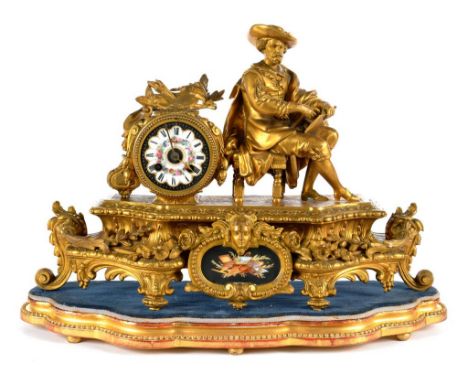 A FRENCH GILTMETAL MANTEL CLOCK, THE DRUM CASED MOVEMENT WITH SEVRES STYLE PAINTED PORCELAIN DIAL, BESIDE THE SEATED FIGURE O