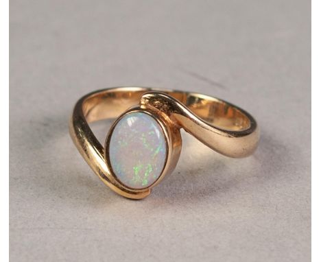 9ct GOLD CROSS-OVER RING collet set with an oval opal 