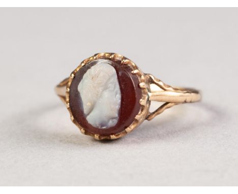 18ct GOLD RING, with a carved cameo opal set into an oval garnet frame, 3gms, ring size 'K' 