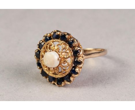 1970's 9ct GOLD RING, the filigree top with an opal in a raised four claw setting, outer circular surround of fourteen small 