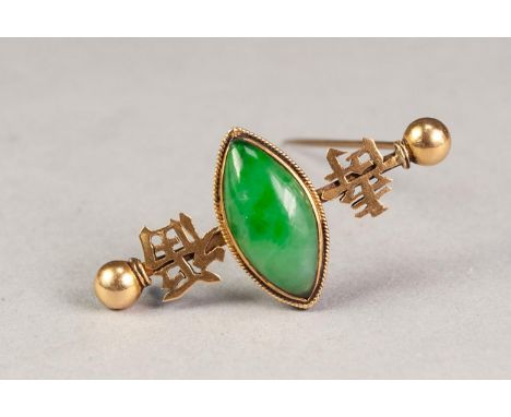 CHINESE GOLD COLOURED METAL BAR BROOCH of dumbell pattern, collet set with a centre lozenge shaped cabochon green jade, flank