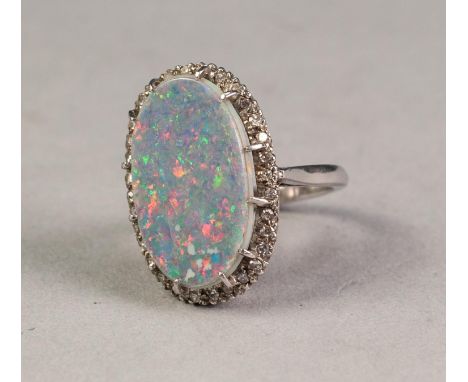 18ct WHITE GOLD, OPAL AND DIAMOND OVAL CLUSTER RING, claw set with a large oval opal doublet over a surround of approximately