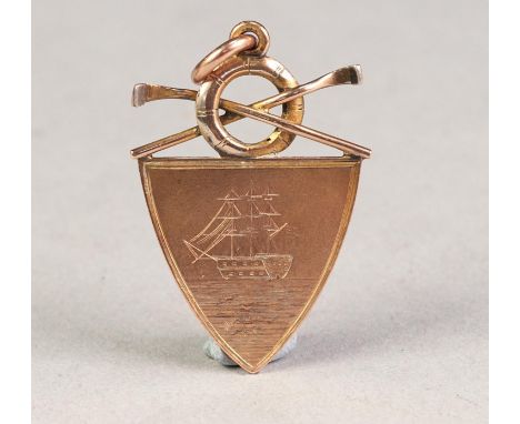 9ct GOLD PRIZE MEDALLION, SHIELD SHAPED WITH LIFEBUOY AND CROSSED OARS SURMOUNTING, the front engraved with an image of 'H.M.