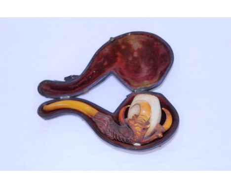 Finely carved and stained late 19th century meerschaum pipe in the form of a dragon or eagle claw holding a cup, amber mouthp
