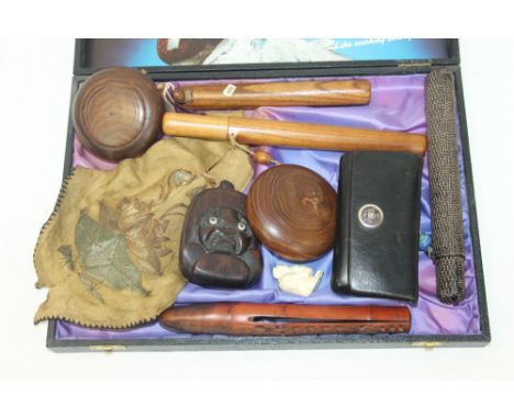 Three Japanese carved pipe holders and ensuite pouches, together with a carved hardwood tobacco box with carved mask cover in