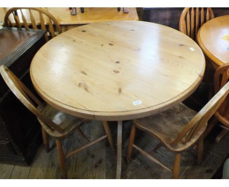 A modern circular Pine breakfast table and two stick back chairs