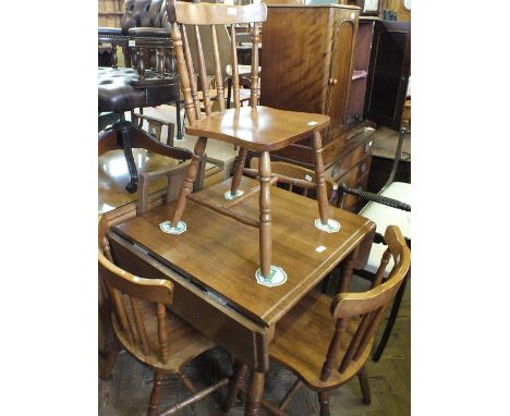 A modern drop leaf table and four stick back chairs