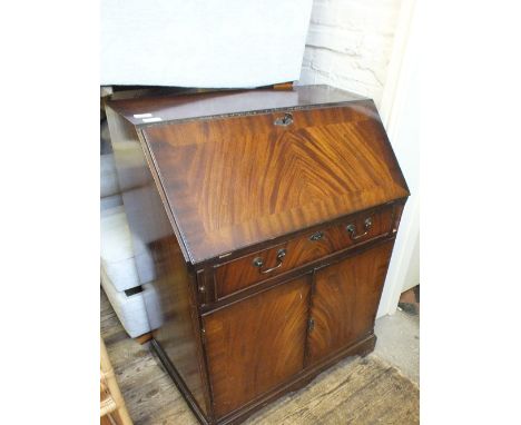 A reproduction Mahogany bureau and a cane open shelf unit